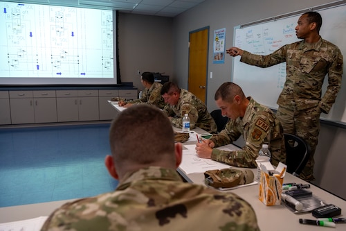 U.S. Air Force Staff Sgt. Maurice Kelly, a vehicle maintenance instructor assigned to the 346th Training Squadron, showcases a diagram for the Halvorsen 25K Cargo Loader to Airmen assigned to multiple vehicle maintenance units, at Muñiz Air National Guard Base, Carolina, Puerto Rico, June 4, 2024.