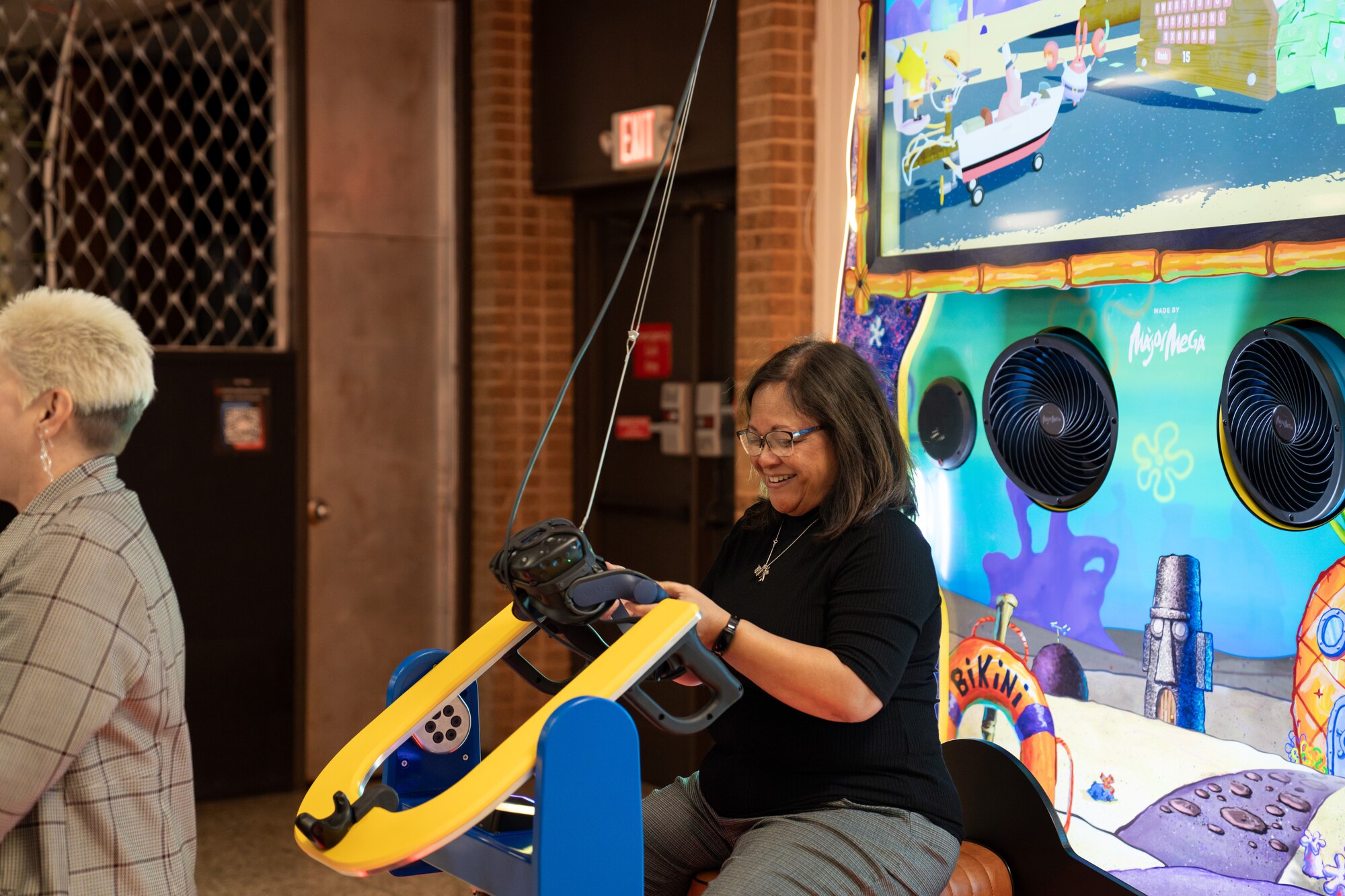 Mrs. Maureen Robinson, spouse of U.S. Air Force Lt. Gen. Brian Robinson, commander of Air Education and Training Command, enjoys an immersive VR game at the Sheppard Air Force Base Afterburner