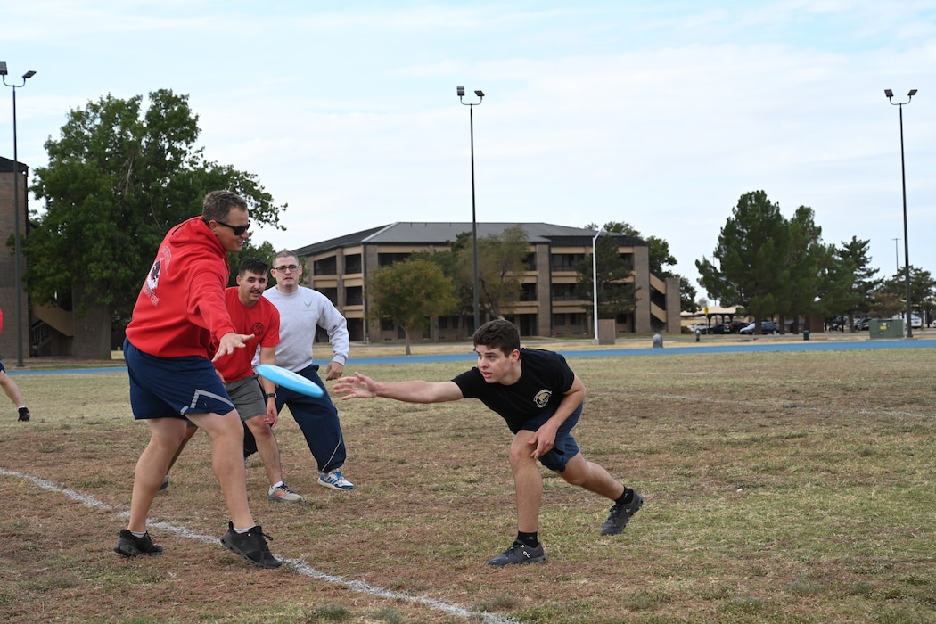 U.S. Air Force Airman 1st Class Jacob Thrasher, 97th Contracting Flight client systems technician, throws a frisbee to Master Sgt. Donald Fisher, 97th Civil Engineer Squadron facilities superintendent, during the 97th Mission Support Group sports day event at Altus Air Force Base, Oklahoma, Oct. 18, 2024. The event featured a line up of 12 activities, including volleyball, basketball, and ultimate frisbee. (U.S. Air Force photo by Airman 1st Class Lauren Torres)