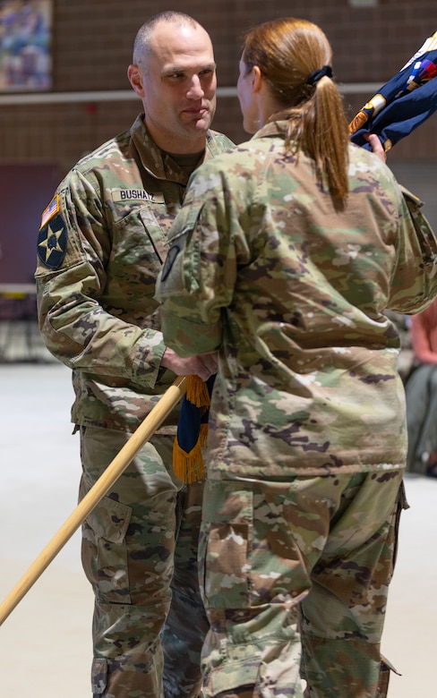 Alaska Army National Guard Lt. Col. Luke Bushatz, left, outgoing commander for the 1st Battalion, 297th Infantry Regiment, passes the colors to Col. Michele Edwards, the commander of the 297th Regional Support Group, as part of a change of command ceremony on Oct. 20, 2024, at Joint Base Elmendorf-Richardson, Alaska.