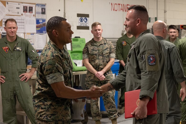 U.S. Marine Corps Sergeant Maj. Cyprian Johnson, left, sergeant major, Marine Aircraft Group 13, congratulates Staff Sgt. Nicholas Bevan, right, airframes mechanic, MALS-13, 3rd MAW (right) at  Marine Corps Air Station Yuma, Arizona, Oct. 9, 2024. Bevan received the Navy and Marine Corps Achievement Medal (NAM) for designing a 3D printable maintenance tool that will be used to help maintain aircrafts for years to come.  (U.S. Marine Corps photo by Lance Cpl. Elizabeth Gallagher)