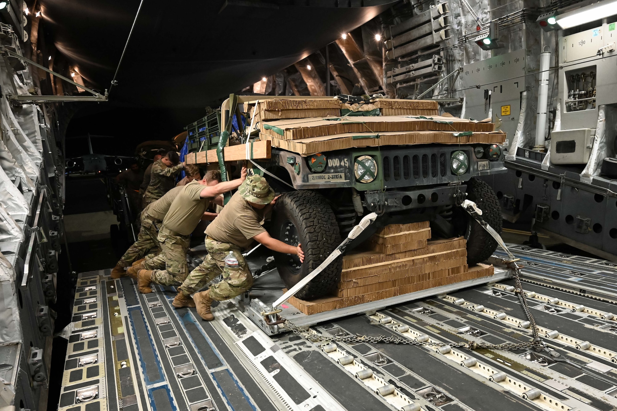 U.S. Army Soldiers from the 725th Brigade Support Battalion, 2nd Infantry Brigade Combat Team, 11th Airborne Division, work alongside a 7th Expeditionary Airlift Squadron loadmaster and leadership from Joint Base Elmendorf-Richardson to load a Humvee onto a McChord C-17 Globemaster III, Oct. 14, 2024.