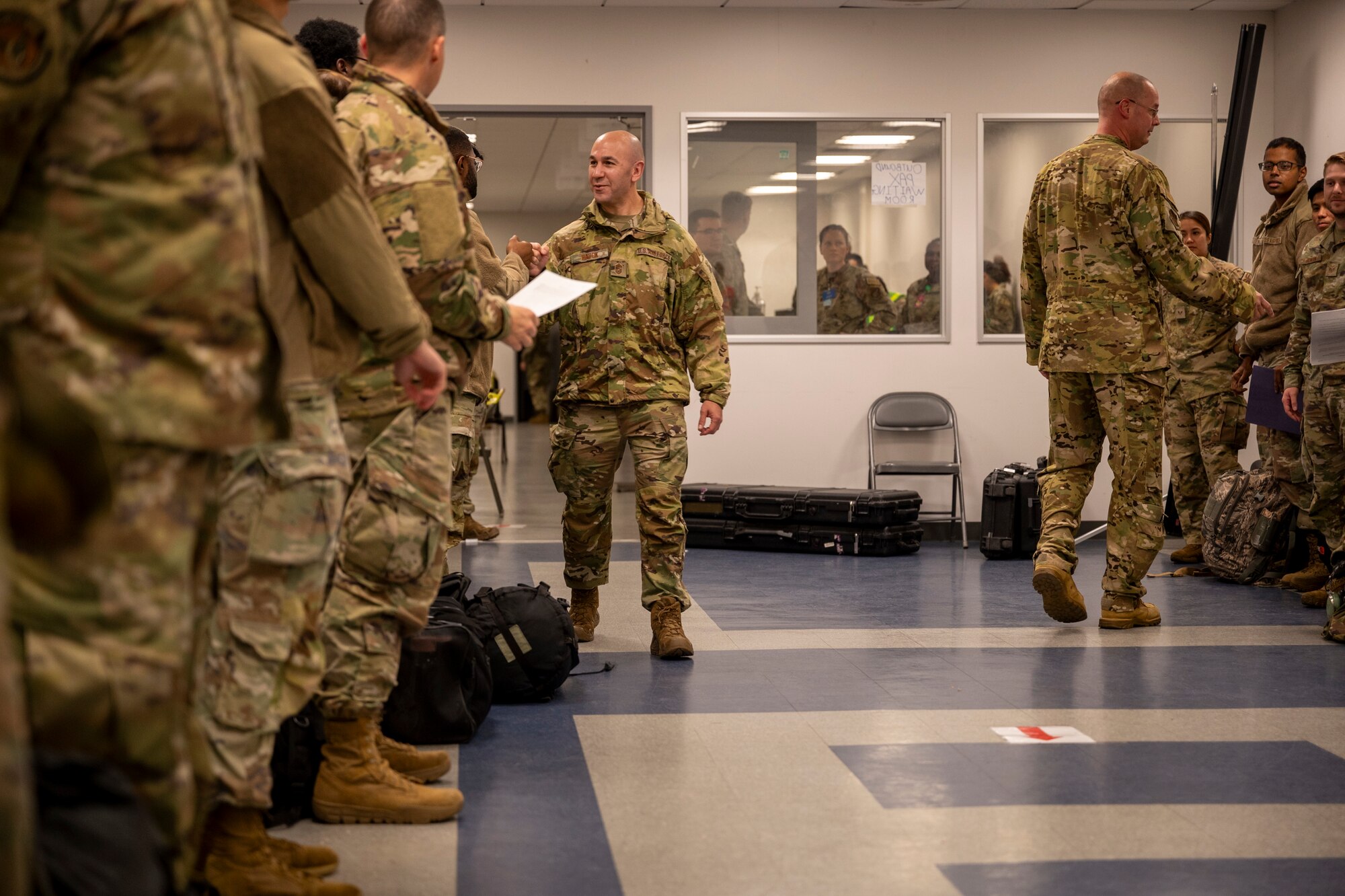 A military member walks down a row of Airmen to fist bump them.