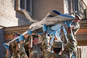 944th Fighter Wing personnel lift the F-16 static display onto its platform at Luke Air Force Base, Ariz., Oct. 17, 2024. The restoration project pays homage to the wing's history and the contributions of its members of the past and present, with a tail flash honoring the 302nd Fighter Squadron and the Tuskegee Airmen. (U.S. Air Force photo by Tech. Sgt. Tyler J. Bolken)