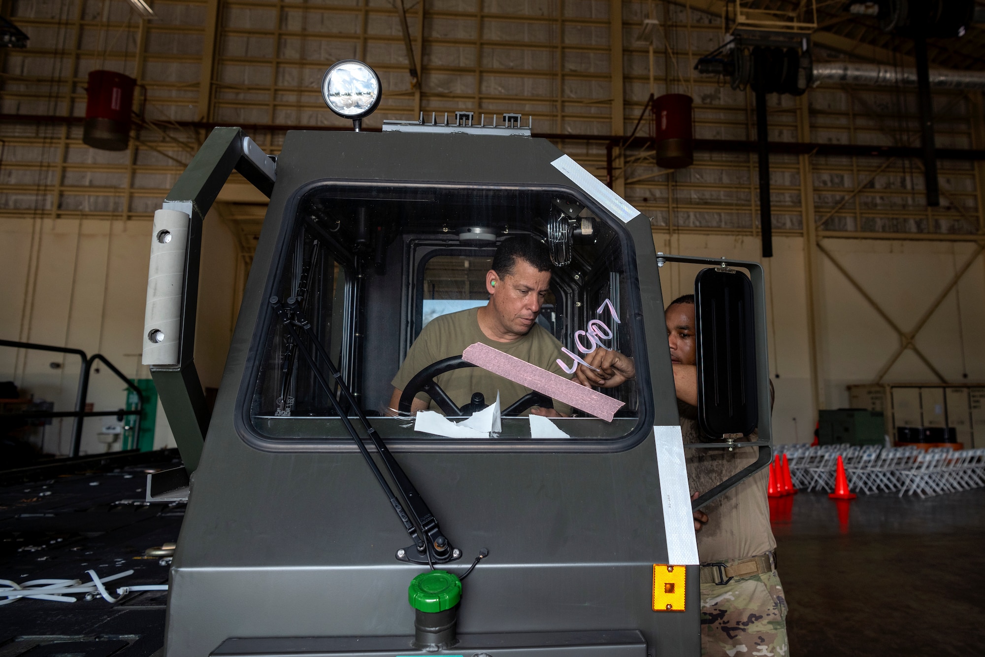 U.S. Air Force Staff Sgt. Maurice Kelly, a vehicle maintenance instructor assigned to the 346th Training Squadron, shows Staff Sgt. Carlos J. Claudio, a vehicle maintenance technician assigned to the 156th Contingency Response Support Squadron, how to operate a Halvorsen 25K Cargo Loader at Muñiz Air National Guard Base, Carolina, Puerto Rico, June 5, 2024.