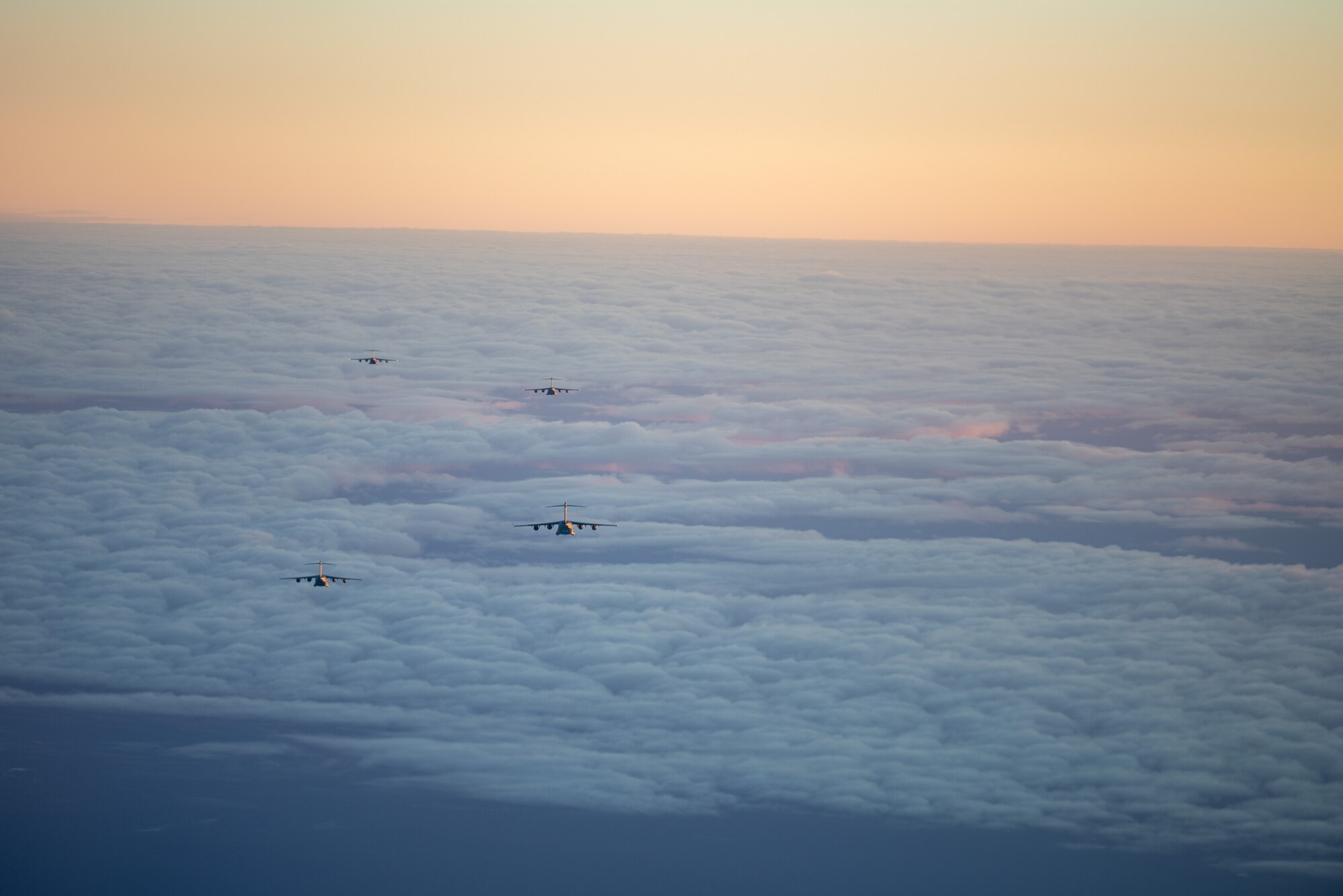 Four U.S. Air Force C-17 Globemaster IIIs fly in formation over Alaska as part of Joint Forcible Entry training, Alaska, Oct. 15, 2024.