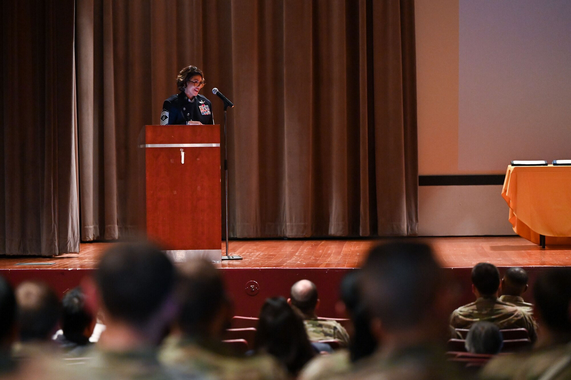 Chief stands on a stage talking to a crowd.