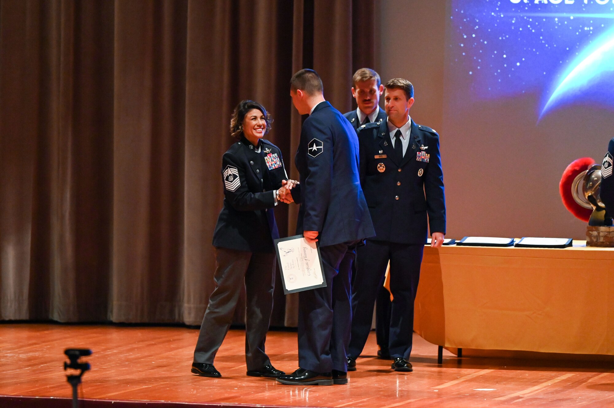 People stand shaking hands on a stage.