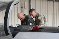 U.S. Air Force Lt. Gen. Brian Robinson, commander of Air Education and Training Command, receives an update from Tech. Sgt. Manuel Jimenez, 80th Flying Training Wing quality assurance inspector