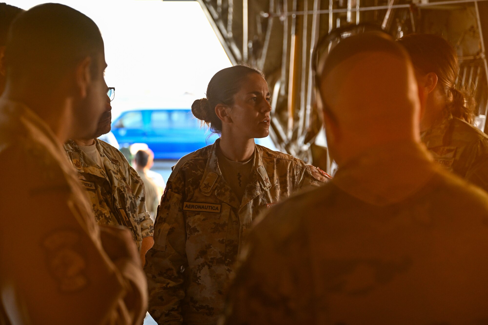 People stand in a group inside of an aircraft.