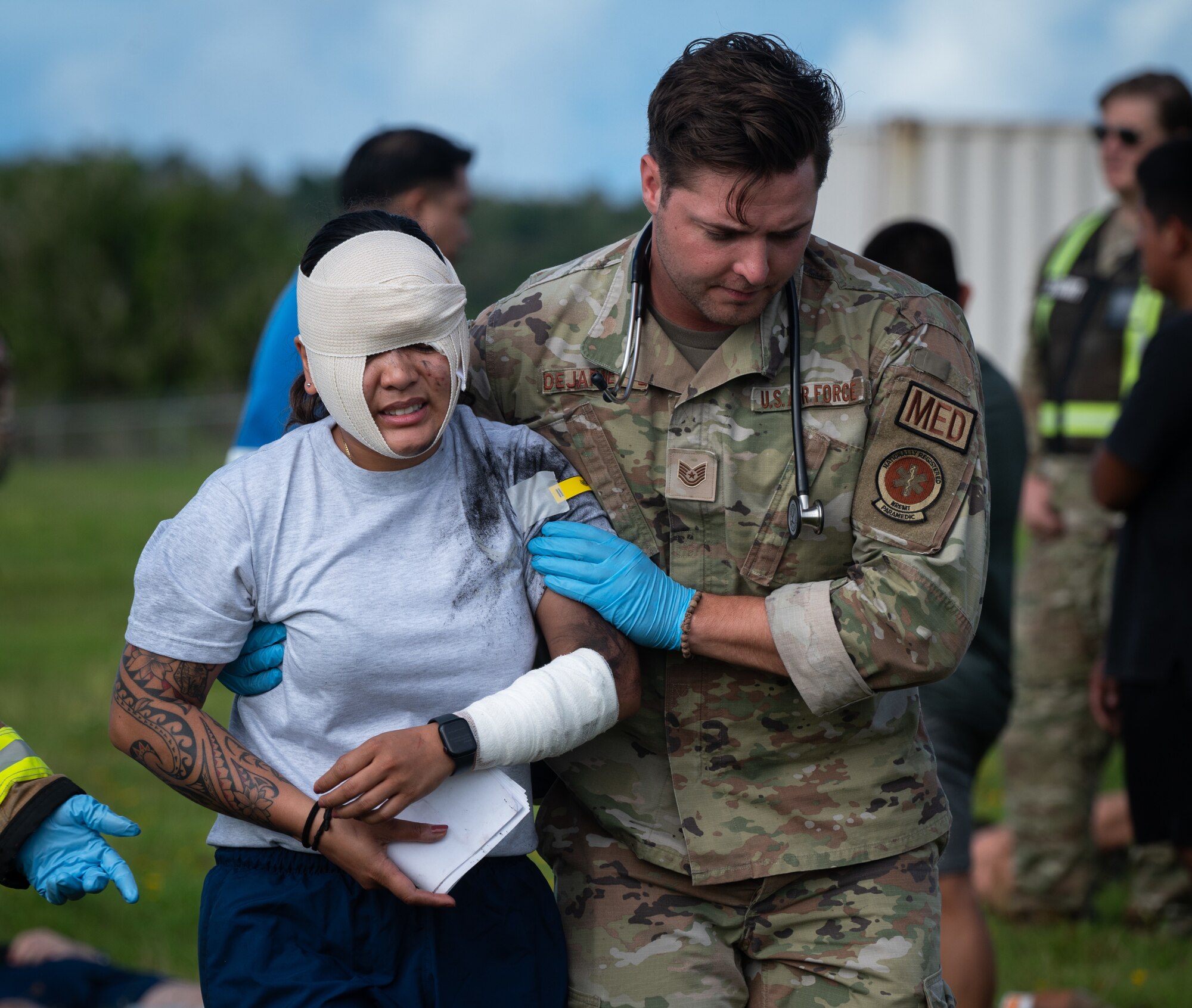 A 36th Medical Group Airman helps a simulated injured Airman during a major accident response exercise (MARE) for Slingstone 24-4 at Andersen Air Force Base, Guam, Oct. 22, 2024. The MARE allows first responders to hone the skills needed should a real accident happen. This scenario included a simulated plane fire and passengers scattered around with various injuries. (U.S. Air Force photo by Staff Sgt. Pedro Tenorio)