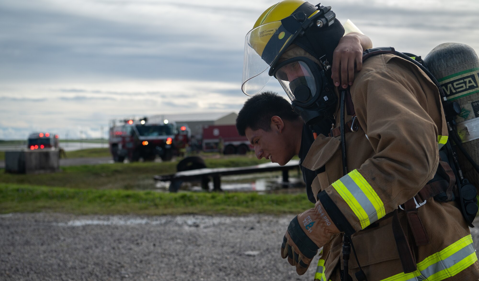 A Andersen Air Force Base Firefighter carries a simulated injured passenger radios during a major accident response exercise (MARE) for Slingstone 24-4 at Andersen AFB, Guam, Oct. 22, 2024. The MARE allows first responders to hone the skills needed should a real accident happen. This scenario included a simulated plane fire and passengers scattered around with various injuries. (U.S. Air Force photo by Staff Sgt. Pedro Tenorio)