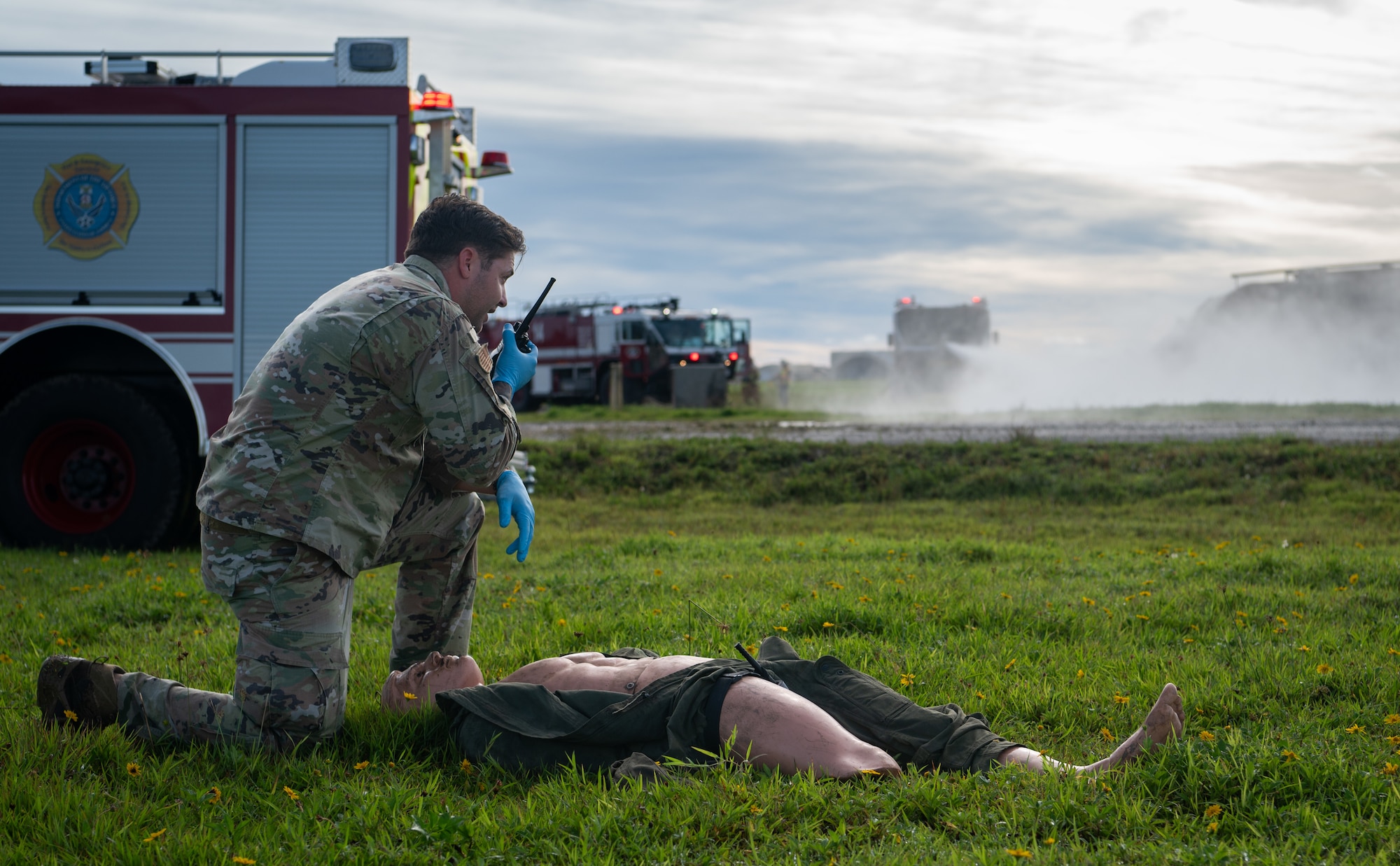 A 36th Medical Group Airman radios his team that there is a casualty during a major accident response exercise (MARE) for Slingstone 24-4 at Andersen Air Force, Guam, Oct. 22, 2024. The MARE allows first responders to hone the skills needed should a real accident happen. This scenario included a plane on fire and passengers scattered around with various injuries. (U.S. Air Force photo by Staff Sgt. Pedro Tenorio)