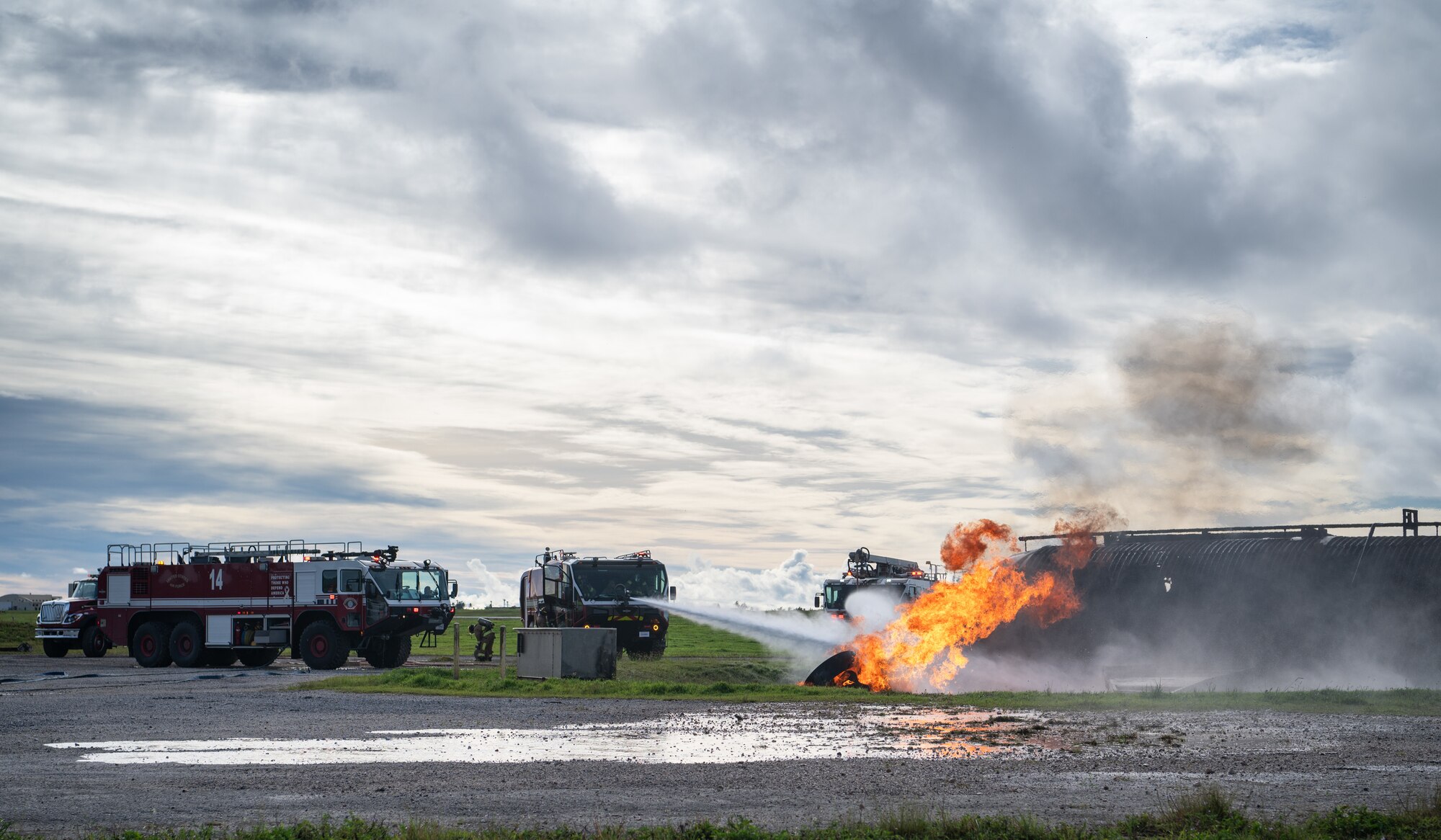 The Andersen Air Force Base Fire Department combats a fire during a controlled burn scenario for Slingstone 24-4 at Andersen Air Force, Guam, Oct. 22, 2024. The Firefighters participated in a major accident response exercise, which allows first responders to hone the skills needed should a real accident happen. This scenario included a plane on fire and passengers scattered around with various injuries. (U.S. Air Force photo by Staff Sgt. Pedro Tenorio)