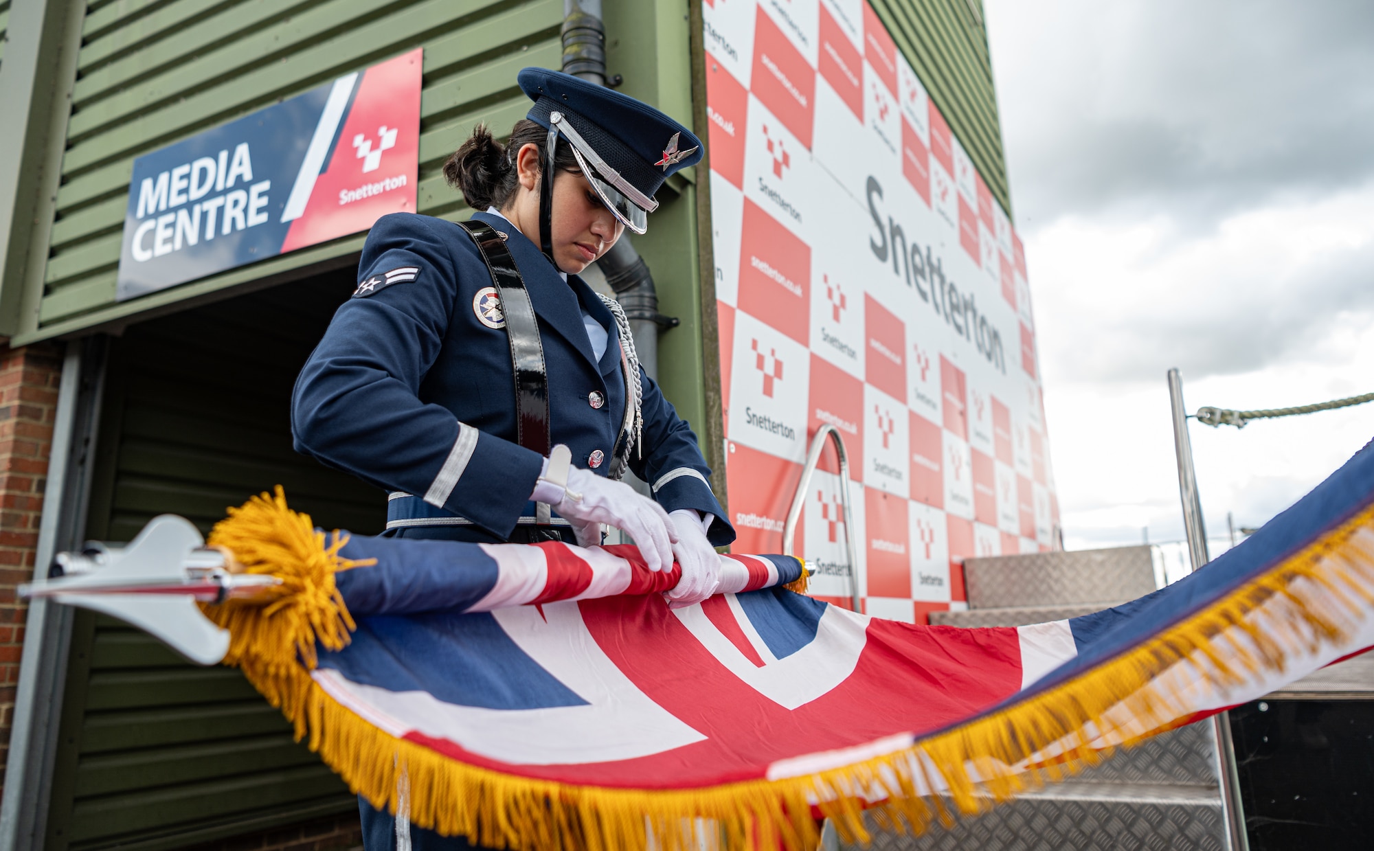 U.S. Air Force Airman 1st Class Naisha Blanco, Royal Air Force Mildenhall Honor Guardsman, rolls the U.K. flag after the USA Snetterton 300 race opening ceremony in Norfolk, England, Sept. 8, 2024.