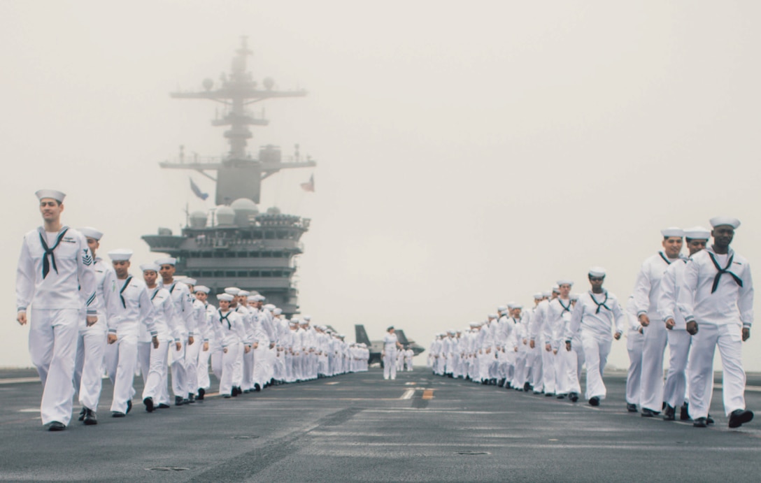 Sailors man rails on flight deck of USS George Washington