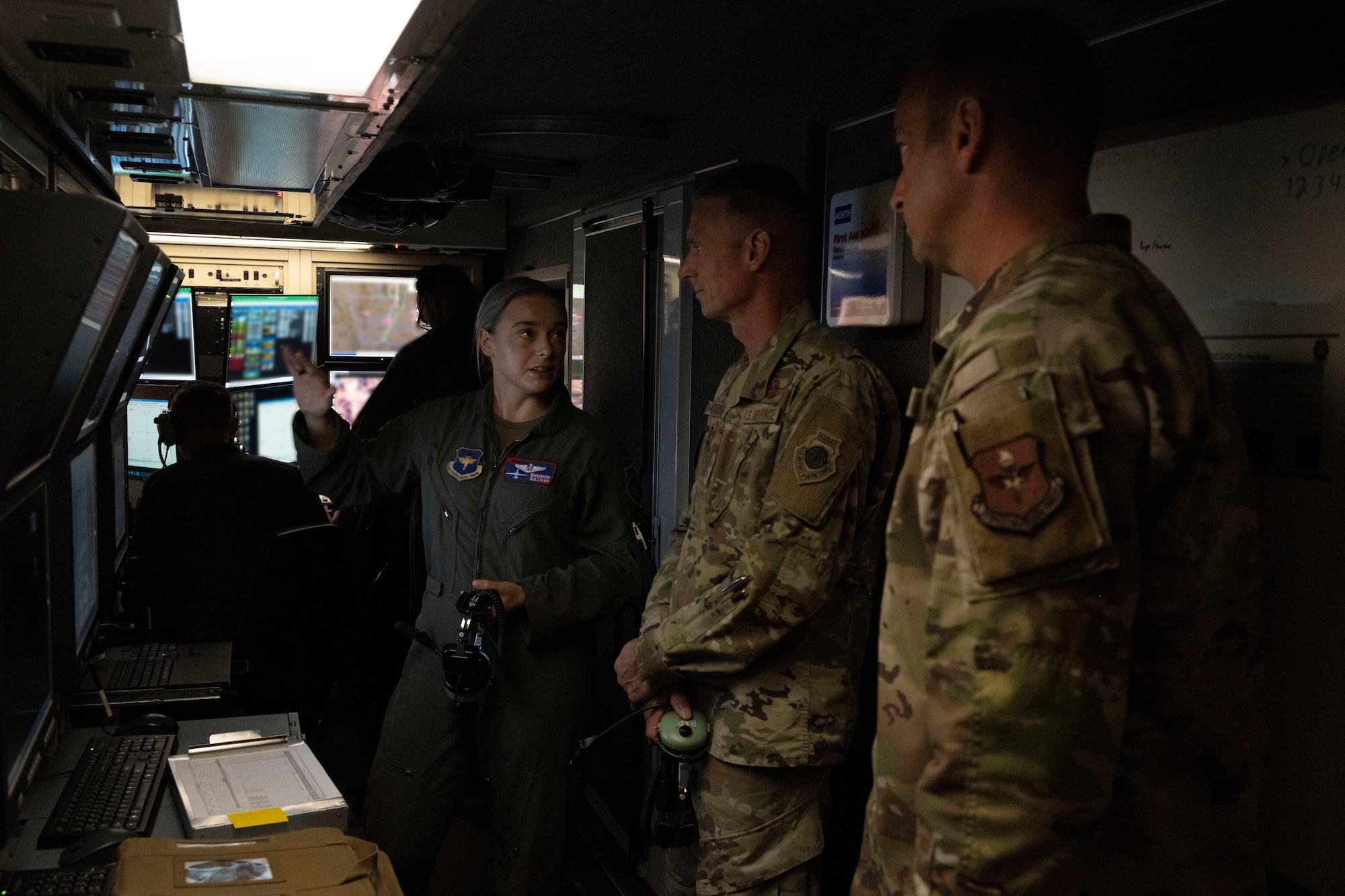 U.S. Air Force Capt. Shannon Sullivan, 9th Attack Squadron chief of weapons and tactics, left, gives a tour of an MQ-9 Reaper ground control station to U.S. Air Force Maj. Gen. Gregory Kreuder, 19th Air Force commander, center, and U.S. Air Force Chief Master Sgt. Keith Scott, 19th Air Force command chief at Holloman Air Force Base, New Mexico, Oct. 8, 2024. Throughout the tour, Kreuder and Scott interacted with Airmen, observed squadron operations, and participated in various hands-on activities. (U.S Air Force photo by Senior Airman Isaiah Pedrazzini)