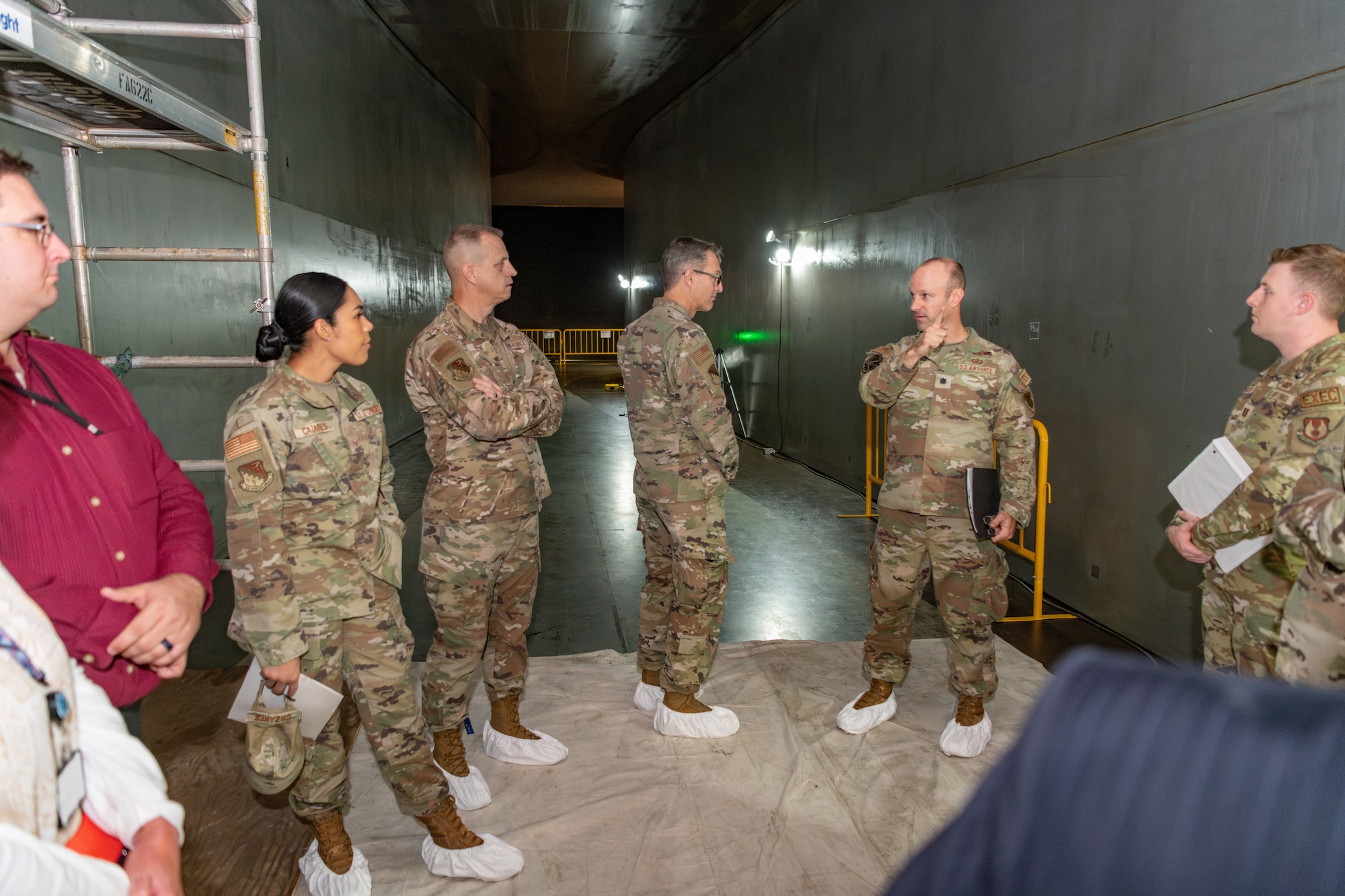 Maj. Gen. Scott A. Cain, Air Force Test Center commander, third from right, tours a wind tunnel while receiving a brief from Lt. Col. Joseph Sabat, commander of the Arnold Engineering Development Complex 716th Test Squadron, second from right, during a recent visit to Arnold Air Force Base, Tenn., headquarters of AEDC. Cain, a previous AEDC commander, visited Arnold Oct. 2-3, 2024, to tour the installation, meet with base personnel and observe operations at Arnold. Also pictured is Chief Master Sgt. Jeffrey Martin, AFTC command chief, third from left. (U.S. Air Force photo by Keith Thornburgh) (This image was altered by obscuring badges for security purposes)