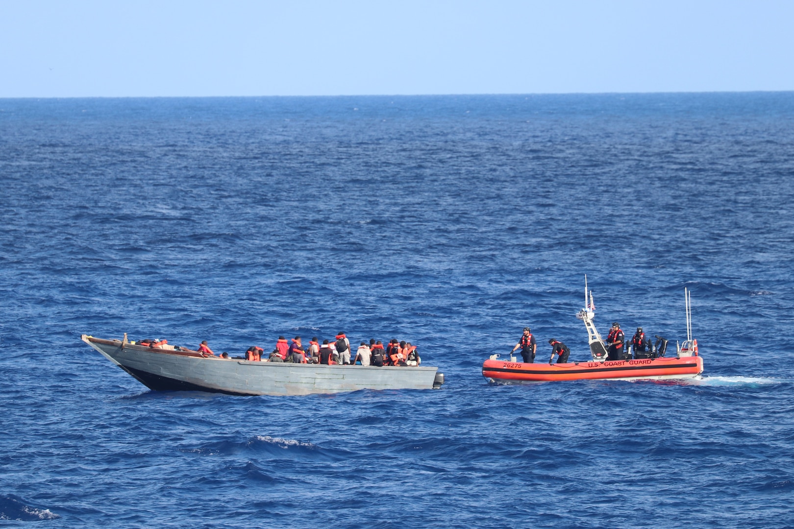 A Coast Guard Cutter Bear (WMEC 901) small boat crew interdicts an overloaded vessel unlawfully bound for the United States by sea with over 100 migrants on board, Sept. 15, 2024, while underway north of Haiti. Operation Vigilant Sentry’s mission is to deter unlawful migration while also making sure that dangerously overloaded vessels are stopped to prevent loss of life at sea. (U.S. Coast Guard photo by Petty Officer 1st Class Jeremy Wilbanks)