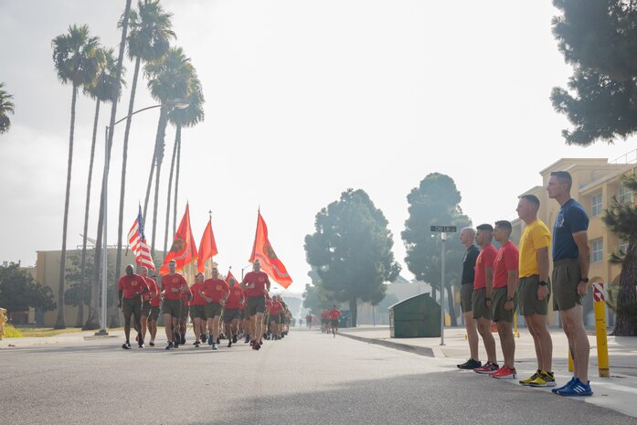 U.S. Marine Corps drill masters with Recruit Training Regiment, stand at attention as the colors pass during the company motivational run for Bravo Company, 1st Recruit Training Battalion, at Marine Corps Recruit Depot San Diego, California, Oct. 10, 2024. The company motivational run is a three-mile cadence run conducted around the Depot and is the last physical training event the Marines will conduct before they graduate from MCRD San Diego. The event is also the first time friends and families will see their newly transformed Marines. (U.S. Marine Corps photo by Lance Cpl. Janell B. Alvarez)