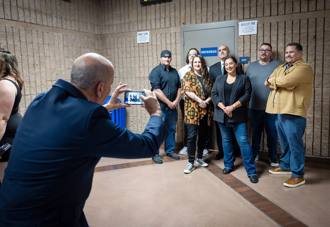 Dave Votroubek, training manager, Shop 71, Painters, Blasters and Tilesetters, takes photos of some of his students before the 2024 Puget Sound Naval Shipyard & Intermediate Maintenance Facility Apprentice Program graduation ceremony, Sept. 20, 2024, at Bremerton High School, in Bremerton, Washington. (U.S. Navy photo by Wendy Hallmark)