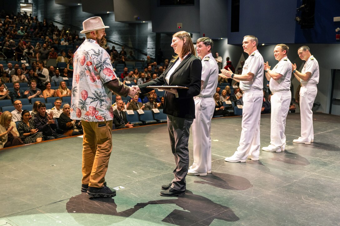 Kenyon Hall, tool maker, Shop 31, Inside Machinist, receives his certificate from Felicienne Griffin, Shop 31 trade superintendent, during the 2024 Puget Sound Naval Shipyard & Intermediate Maintenance Facility Apprentice Program graduation ceremony, Sept. 20, 2024, at Bremerton High School in Bremerton, Washington. (U.S. Navy photo by Wendy Hallmark)