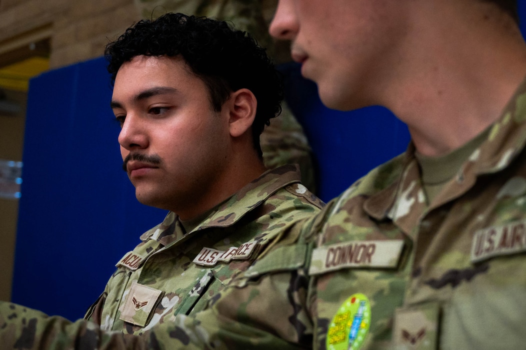 U.S. Airman 1st Class Elijah Acuna, 56th Medical Group aerospace medical technician, fills out incoming patient information for vaccinations.