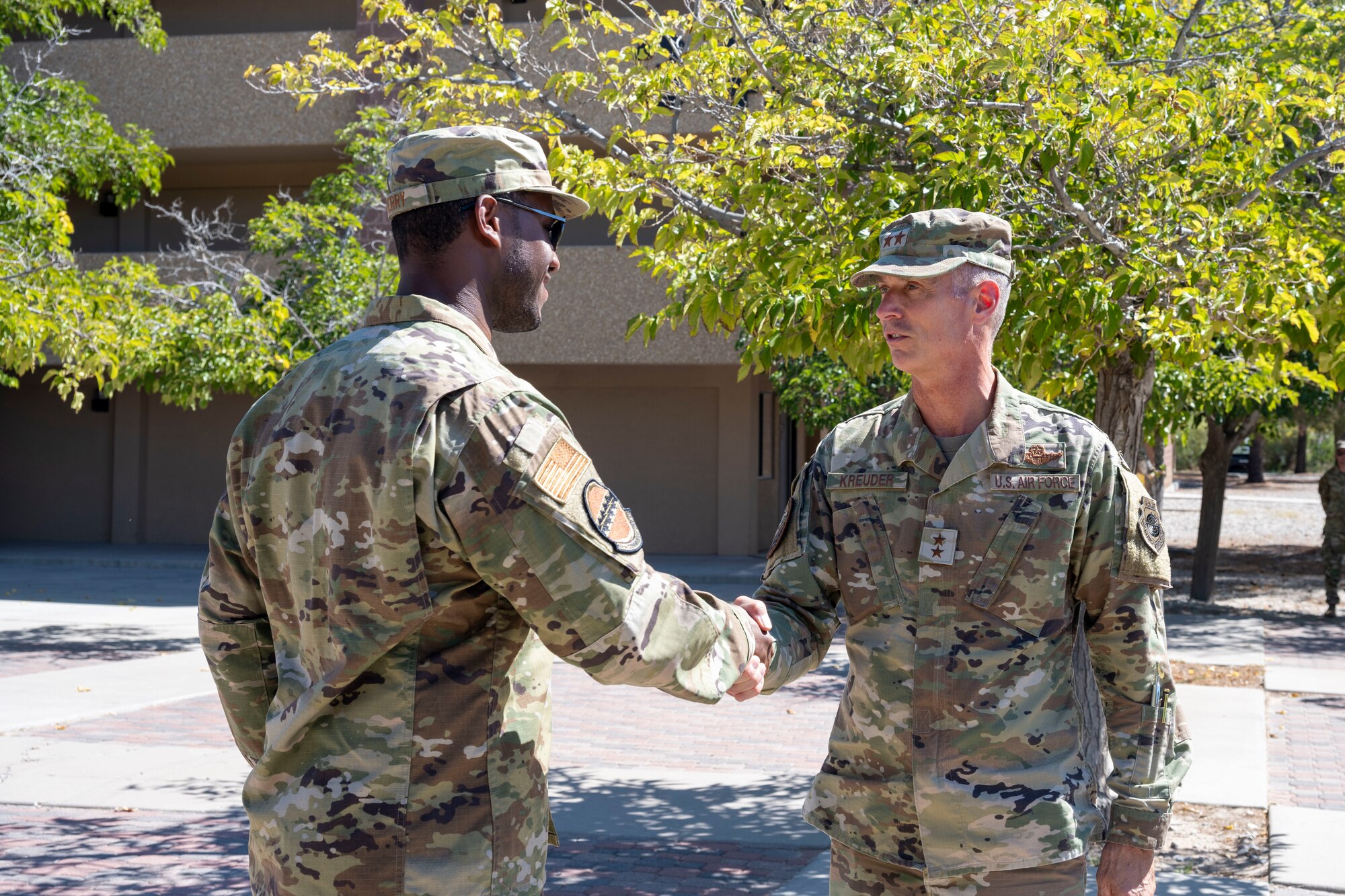 U.S. Air Force Maj. Gen. Gregory Kreuder, 19th Air Force commander, right, coins U.S. Air Force Tech. Sgt. Dre Perry, 49th Communications Squadron base equipment custodian at Holloman Air Force Base, New Mexico, Oct. 8, 2024. The 19th Air Force Command Team visited Holloman Air Force Base to evaluate the installation's capabilities, identify areas for improvement, and explore how the 19th AF can enhance support for the installation. (U.S Air Force photo by Senior Airman Isaiah Pedrazzini)