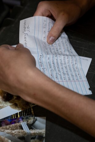 A U.S. Marine Corps recruit with Kilo Company, 3rd Recruit Training Battalion, reads his mail during senior drill instructor square away time at Marine Corps Recruit Depot San Diego, California, Oct. 8, 2024. SDI time is periodically scheduled to enable senior drill instructors to have the opportunity to address instructional remediation, core values reinforcement, mentorship, coaching and future training preparation. (U.S. Marine Corps photo by Lance Cpl. Janell B. Alvarez) (This photo has been altered for security purposes by blurring out a letter)