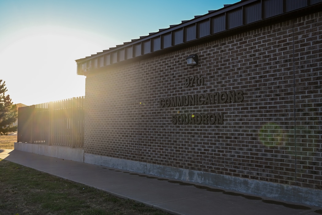 Photo of the 97th Communications Squadron building at Altus Air Force Base, Oklahoma, Oct. 22, 2024. The squadron develops and implements Information Technology solutions, provides knowledge management, information assurance, and communications security functions in support of the ‘Mighty 97th’ mission. (U.S. Air Force photo illustration by Airman 1st Class Lauren Torres)