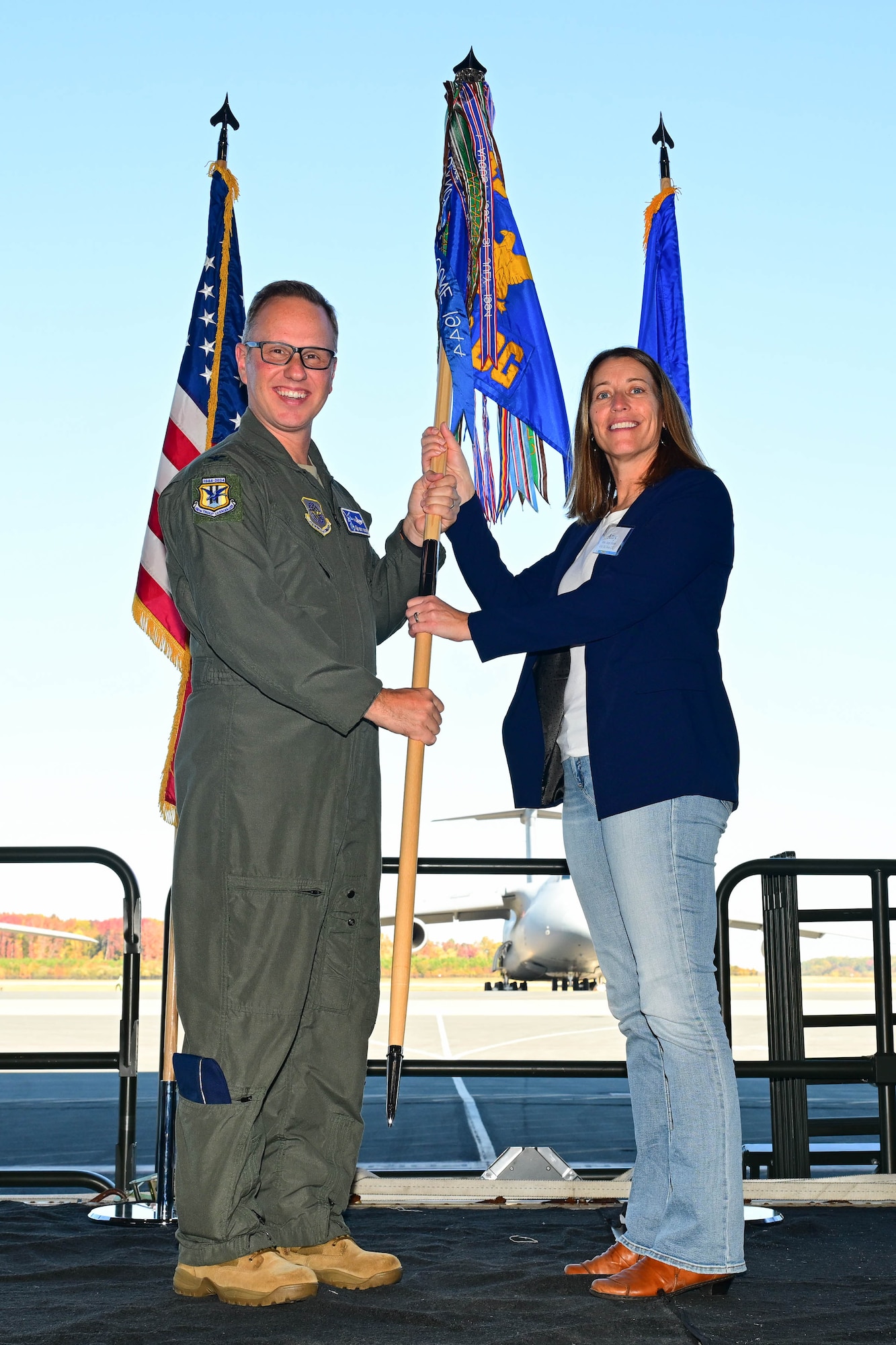 U.S. Air Force Col. Kenneth Weiner, 436th Operations Group commander, left, and Amy Heers, Boston Beer Company associate director of communications, pose with the 436th OG guidon at the 2025 Honorary Commanders Induction Ceremony at Dover Air Force Base, Delaware, Oct. 22, 2024. Heers was one of 45 local civic and business leaders inducted into the HCC program. (U.S. Air Force photo by Mauricio Campino)