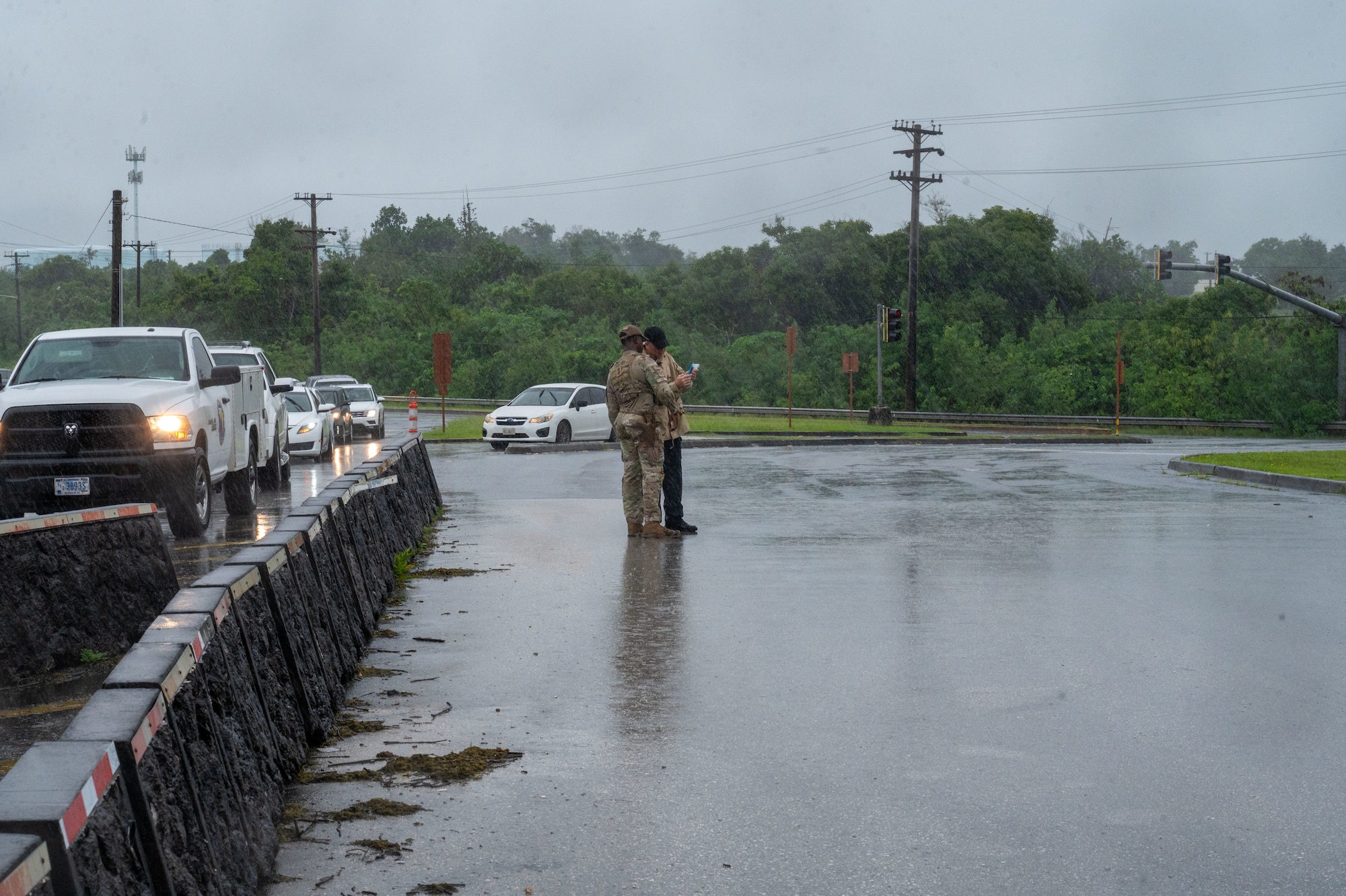 U.S. Air Force Airmen 1st Class Jerron Ford, 36th Security Forces Squadron defender, confronts an individual trying to take photos of the main gate at Andersen Air Force Base, Guam, Oct. 21, 2024. As part of Exercise Slingstone 24-4, the defenders were given an opportunity to practice confronting a simulated visitor who posed a security threat by taking suspicious photos. (U.S. Air Force photo by Airmen 1st Class Manasseh Demissie)