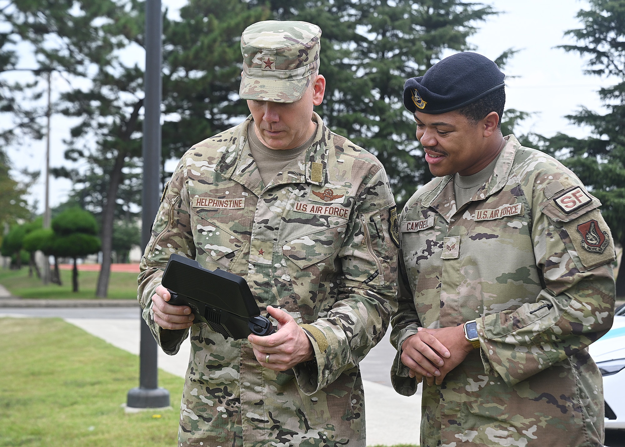 U.S. Air Force Brig. Gen. Kurt Helphinstine, 7th Air Force deputy commander, left, flies an unmanned aerial vehicle alongside Senior Airman Marcus Campbell II, 8th Security Forces Squadron defender.