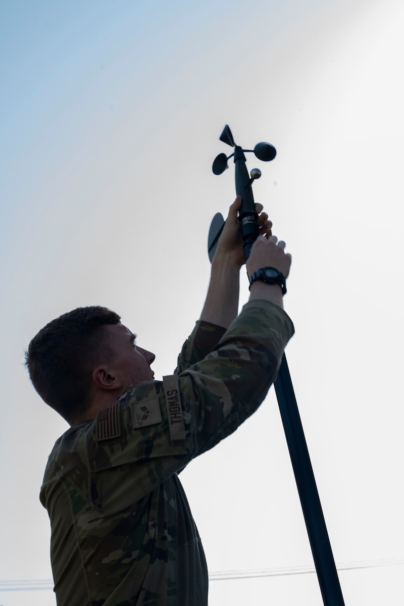 An Airman sets up a weather sensor