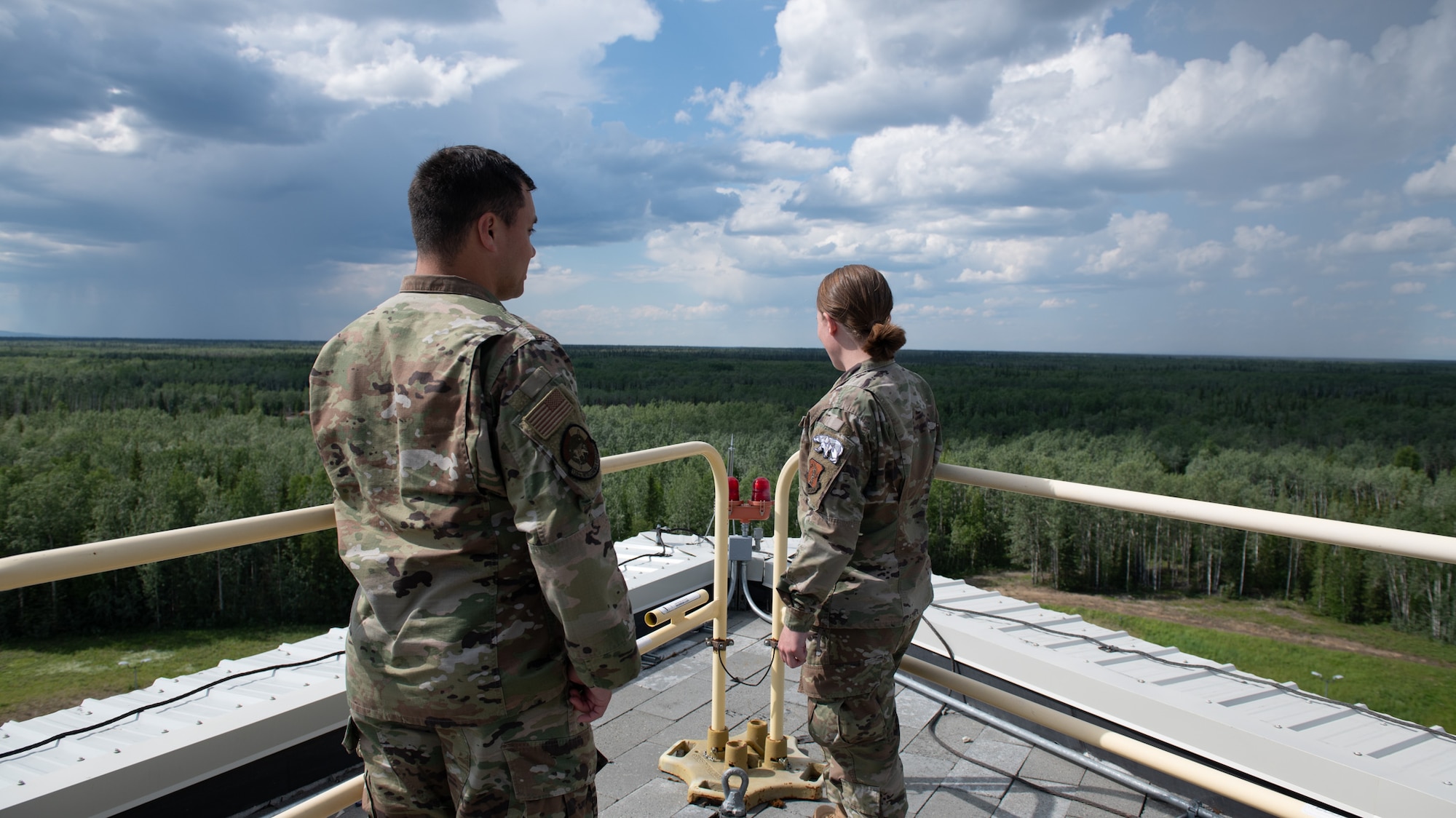U.S. Airmen assigned to the 126th Intelligence Squadron look out on the Alaskan wilderness on top of the radar station that detects incoming ballistic and submarine-launched missiles at the 213th Space Warning Squadron at Clear Space Force Station, Alaska, June 21, 2024. Polar Surge is a joint effort between the 178th Wing and 213th to provide space surveillance data to the NORAD Space Control Center.
