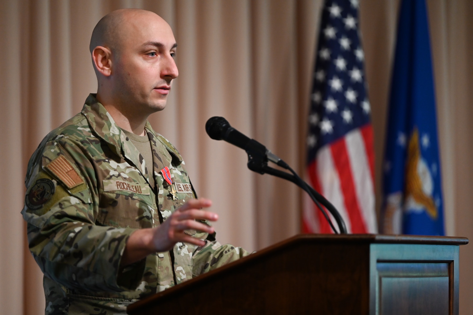 Airman speaks at podium.