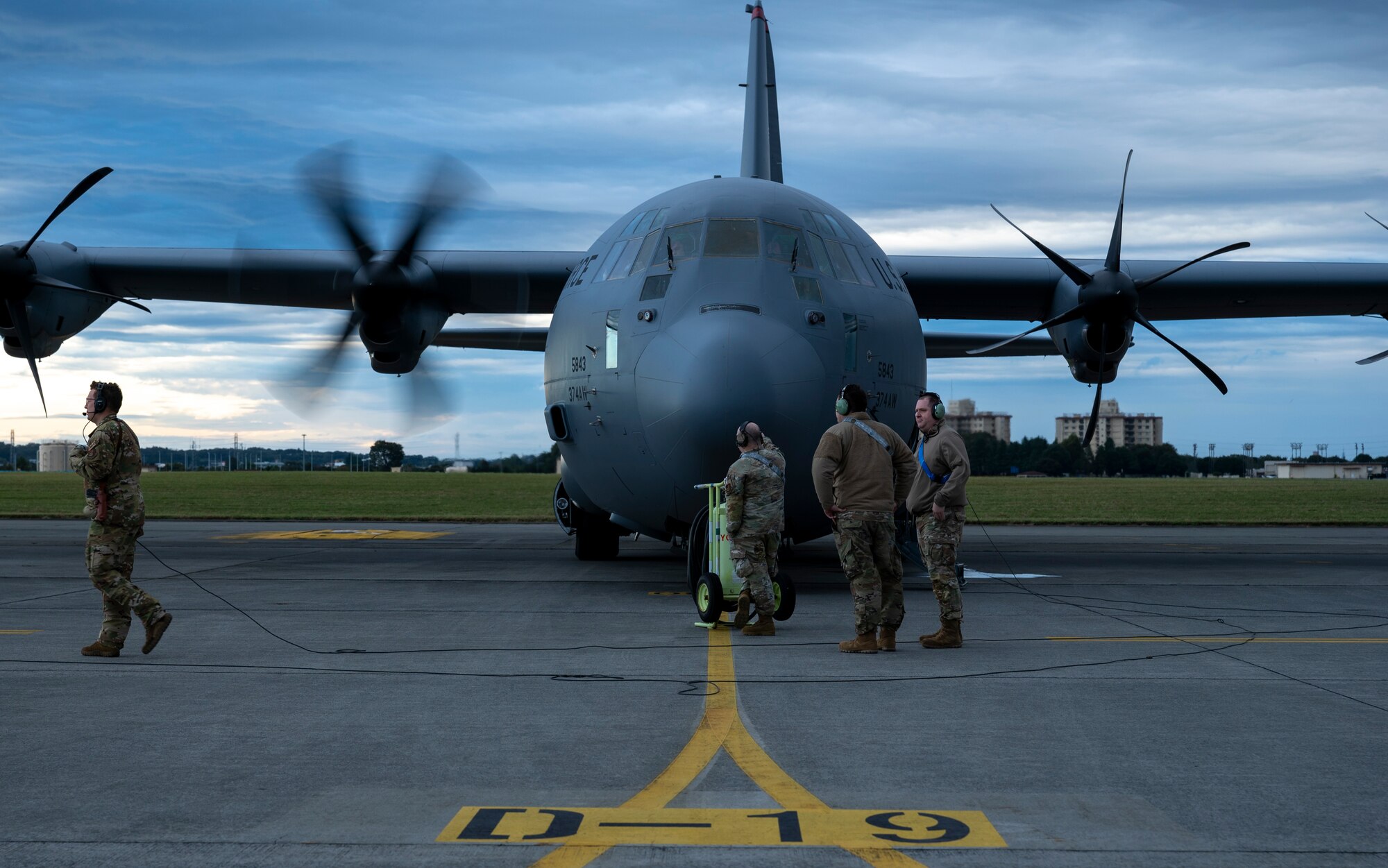 Military members conduct pre flight inspections in front of a C-130J Super Hercules aircraft.