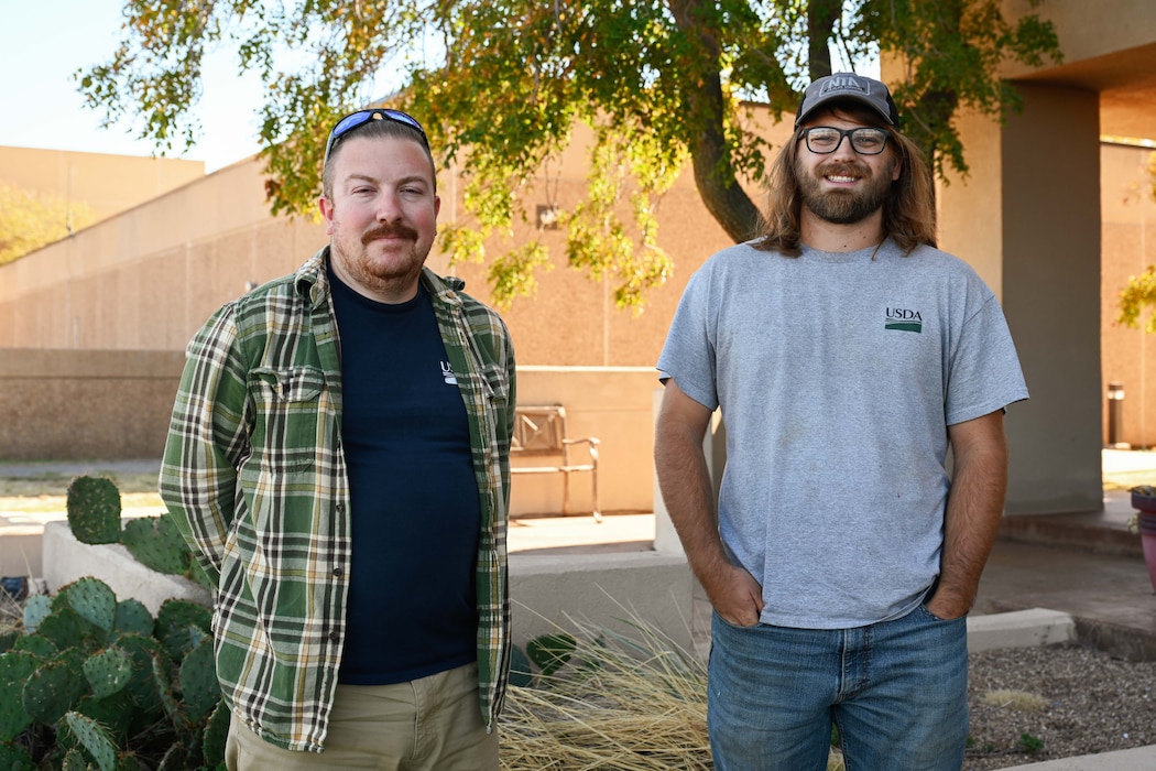 Zach Boucher (left) and Mitchell Singer (right), U.S. Department of Agriculture wildlife specialists, pose for a photo at Altus Air Force Base (AFB), Oklahoma, Oct. 22, 2024. As a team, the wildlife specialists on base have relocated 22 birds from Altus AFB this year alone. (U.S. Air Force photo by Airman 1st Class Jonah Bliss)