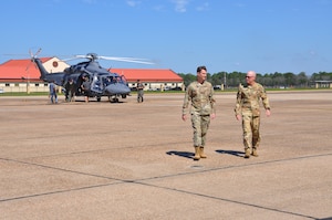 two men walk away from a helicopter