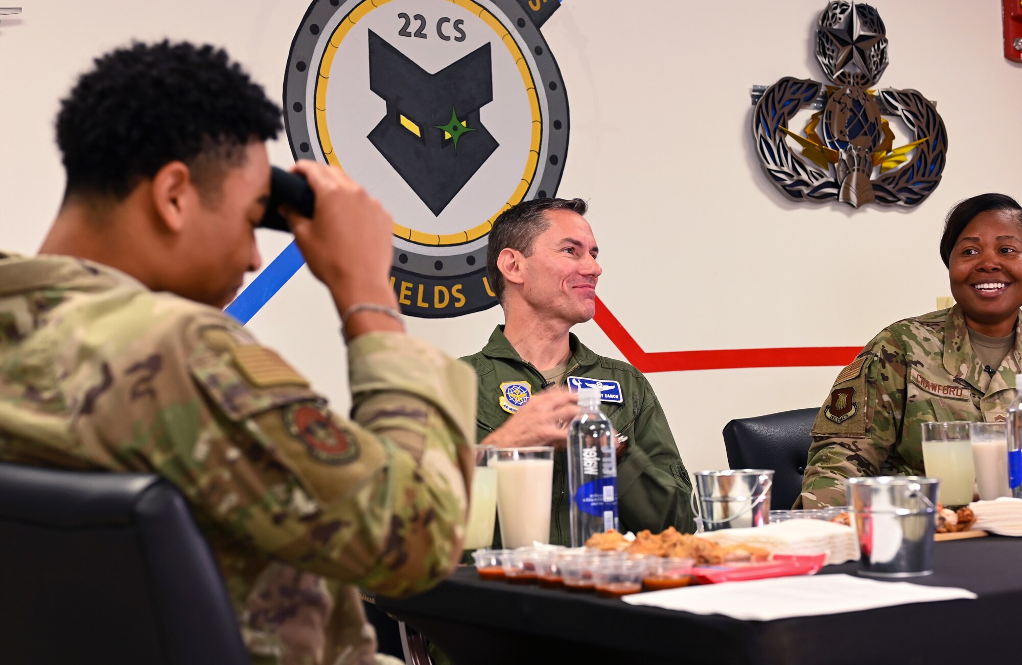 Airman Omar Presley, left, 22nd Communications Squadron communication security clerk, wipes his forehead during the 22nd CS Cybersecurity Office Spicy Ones challenge Oct. 7, 2024, at McConnell Air Force Base, Kansas. Omar interviewed Col. Cory Damon, middle, 22nd Air Refueling Wing commander, and Chief Master Sgt. Markiesha Crawford, 22nd ARW command chief, while they ate increasingly hot chicken wings to raise awareness for Cybersecurity Awareness Month. (U.S. Air Force photo by Staff Sgt. Tryphena Mayhugh)
