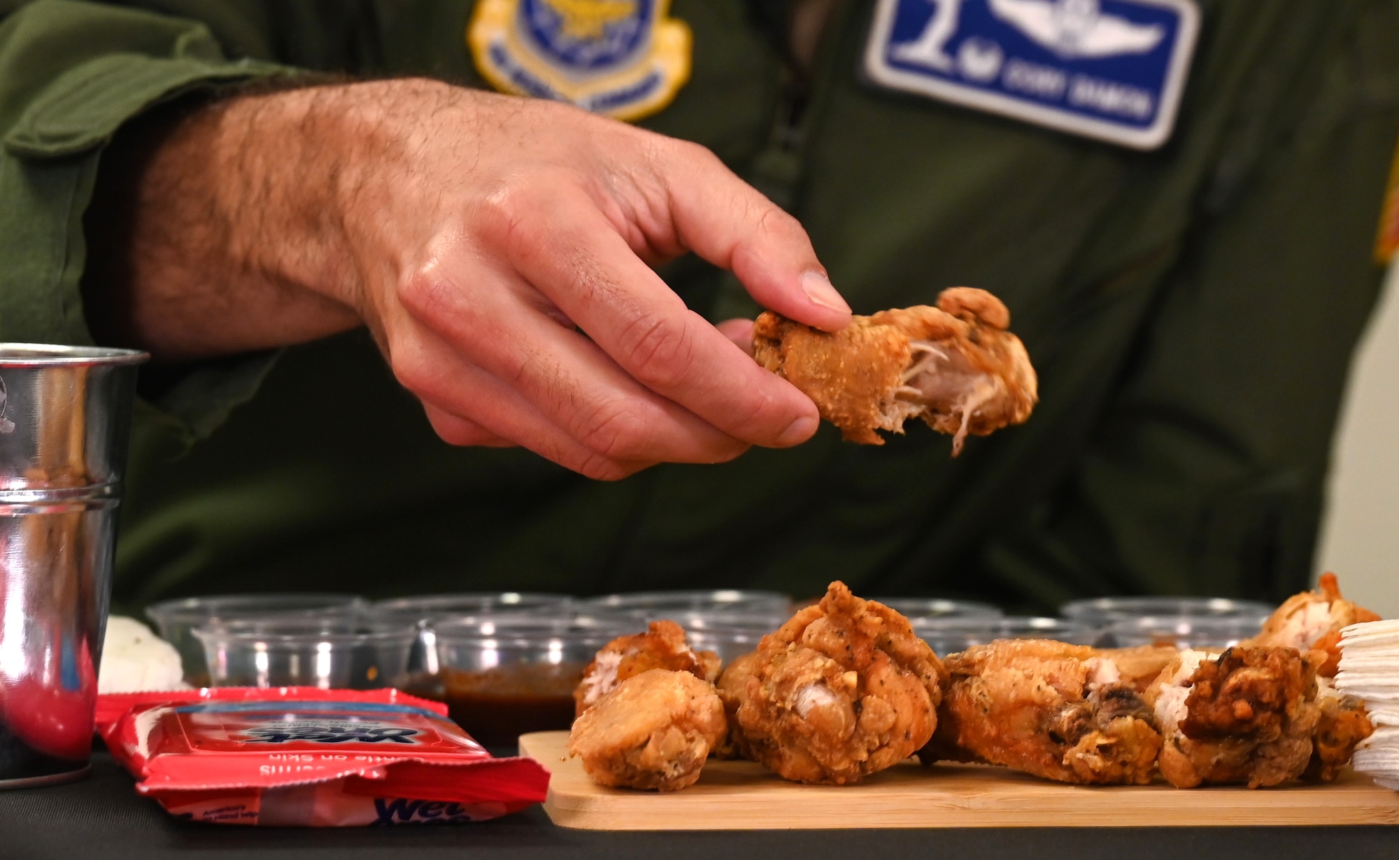 Col. Cory Damon, 22nd Air Refueling Wing commander, picks up a chicken wing during the 22nd Communications Squadron Cybersecurity Office Spicy Ones challenge Oct. 7, 2024, at McConnell Air Force Base, Kansas. Damon, along with Chief Master Sgt. Markiesha Crawford, 22nd ARW command chief, answered questions about cybersecurity and their careers while eating progressively hotter chicken wings for Cybersecurity Awareness Month. (U.S. Air Force photo by Staff Sgt. Tryphena Mayhugh)