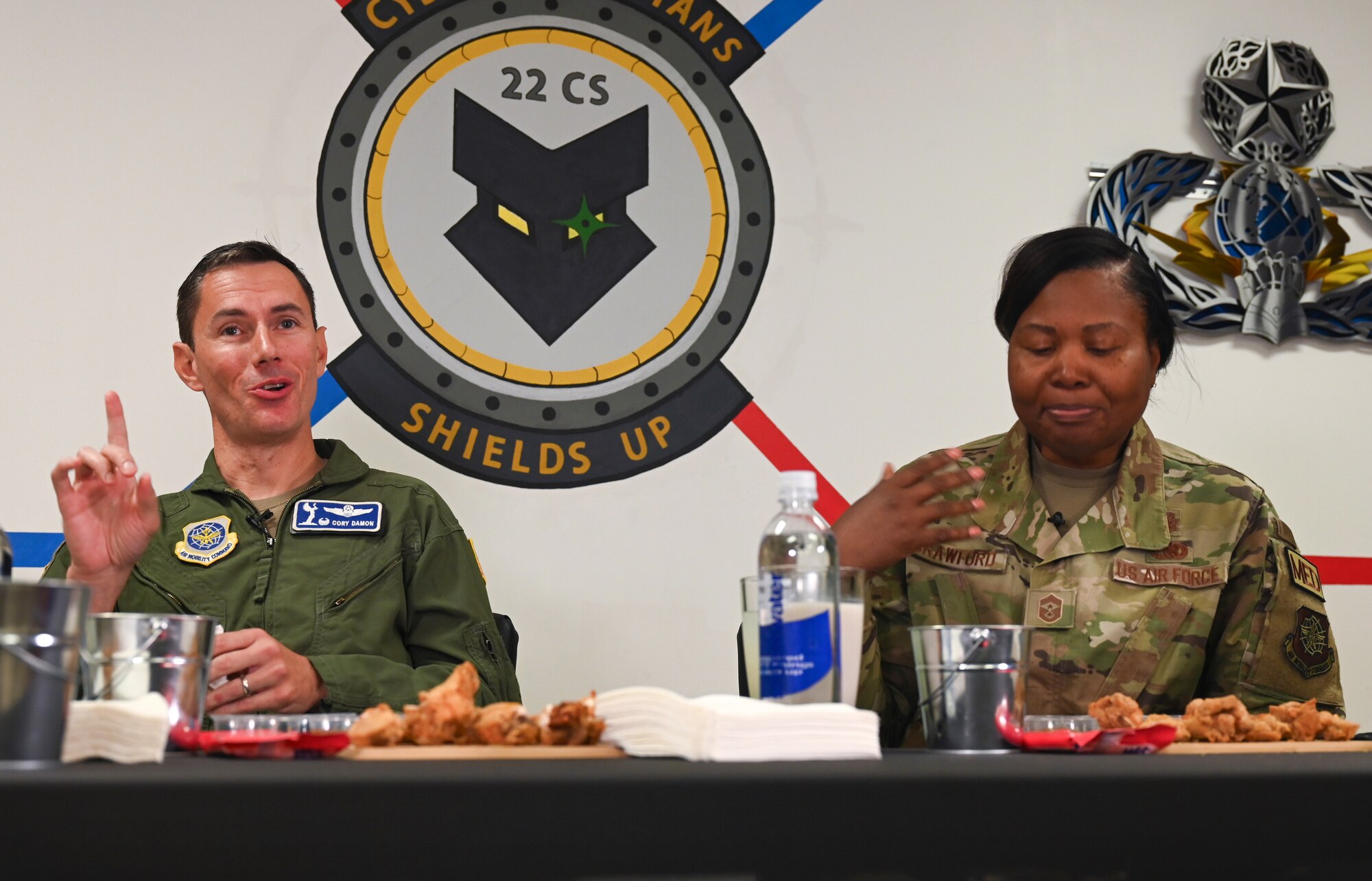 Col. Cory Damon, left, 22nd Air Refueling Wing commander, and Chief Master Sgt. Markiesha Crawford, 22nd ARW command chief, participate in the 22nd Communications Squadron Cybersecurity Office Spicy Ones challenge Oct. 7, 2024, at McConnell Air Force Base, Kansas. To raise awareness for Cybersecurity Awareness Month, Damon and Crawford answered questions about cybersecurity and their careers while eating chicken wings dipped in hot sauces ranging from 1,700 to almost 2.7 million Scoville units. (U.S. Air Force photo by Staff Sgt. Tryphena Mayhugh)