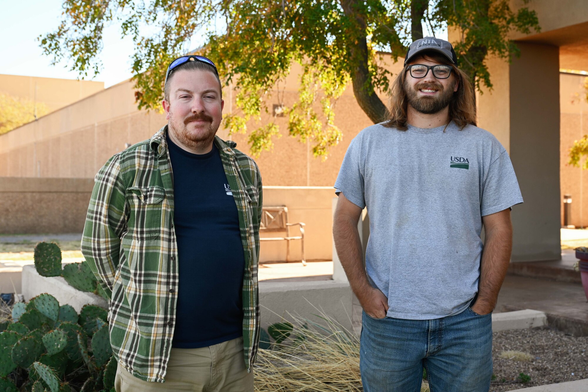 Zach Boucher (left) and Mitchell Singer (right), U.S. Department of Agriculture wildlife specialists, pose for a photo at Altus Air Force Base (AFB), Oklahoma, Oct. 22, 2024. As a team, the wildlife specialists on base have relocated 22 birds from Altus AFB this year alone. (U.S. Air Force photo by Airman 1st Class Jonah Bliss)
