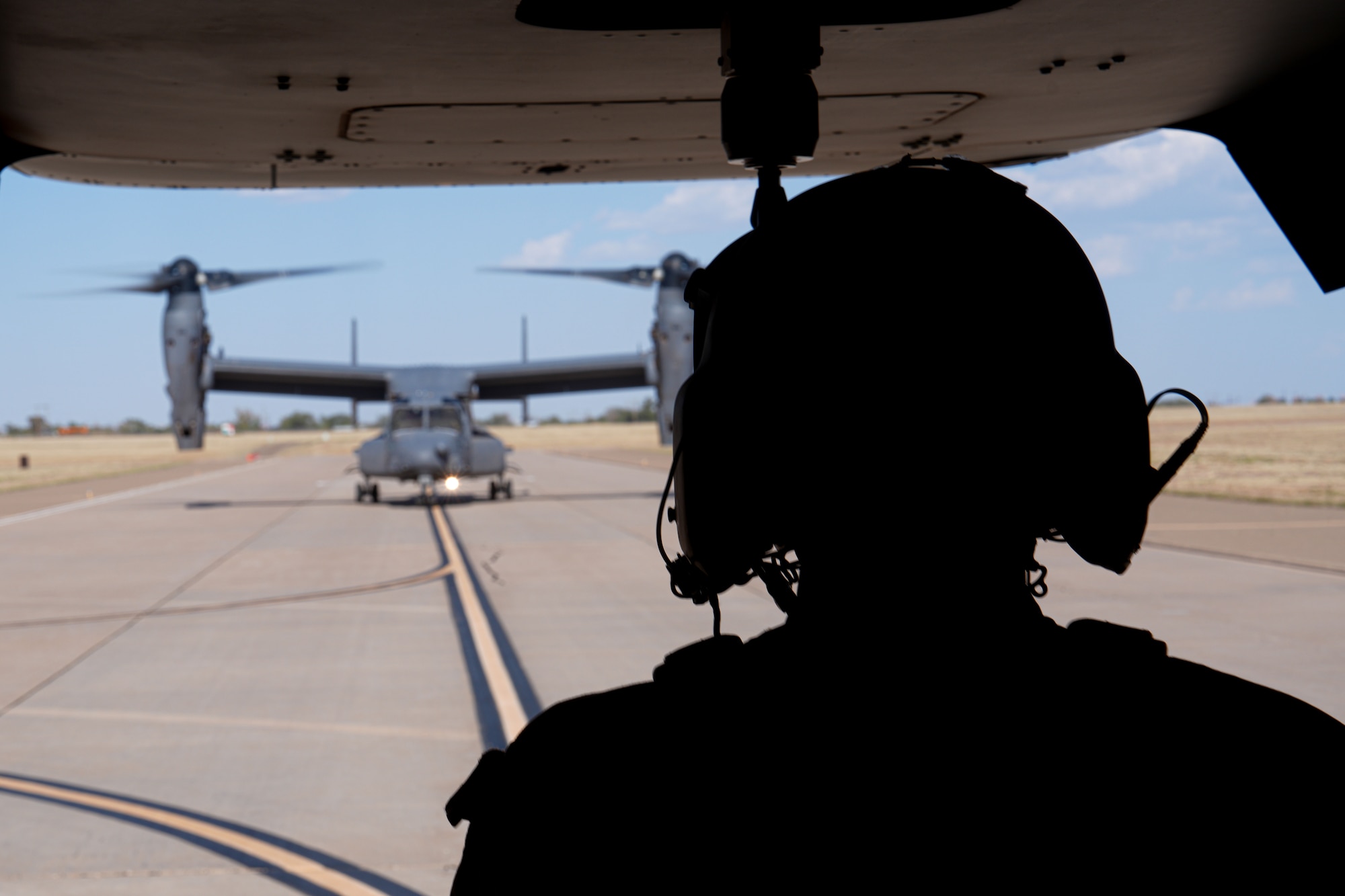 A U.S. Air Force Airman assigned to the 20th Special Operations Squadron prepares for take off aboard a CV-22 Osprey at Cannon Air Force Base, New Mexico, Oct. 9, 2024. The CV-22 takes off vertically and, once airborne, the nacelles on each wing can rotate into a forward position to fly with the speed characteristics of a turboprop aircraft. (U.S. Air Force photo by Airman 1st Class Gracelyn Hess)