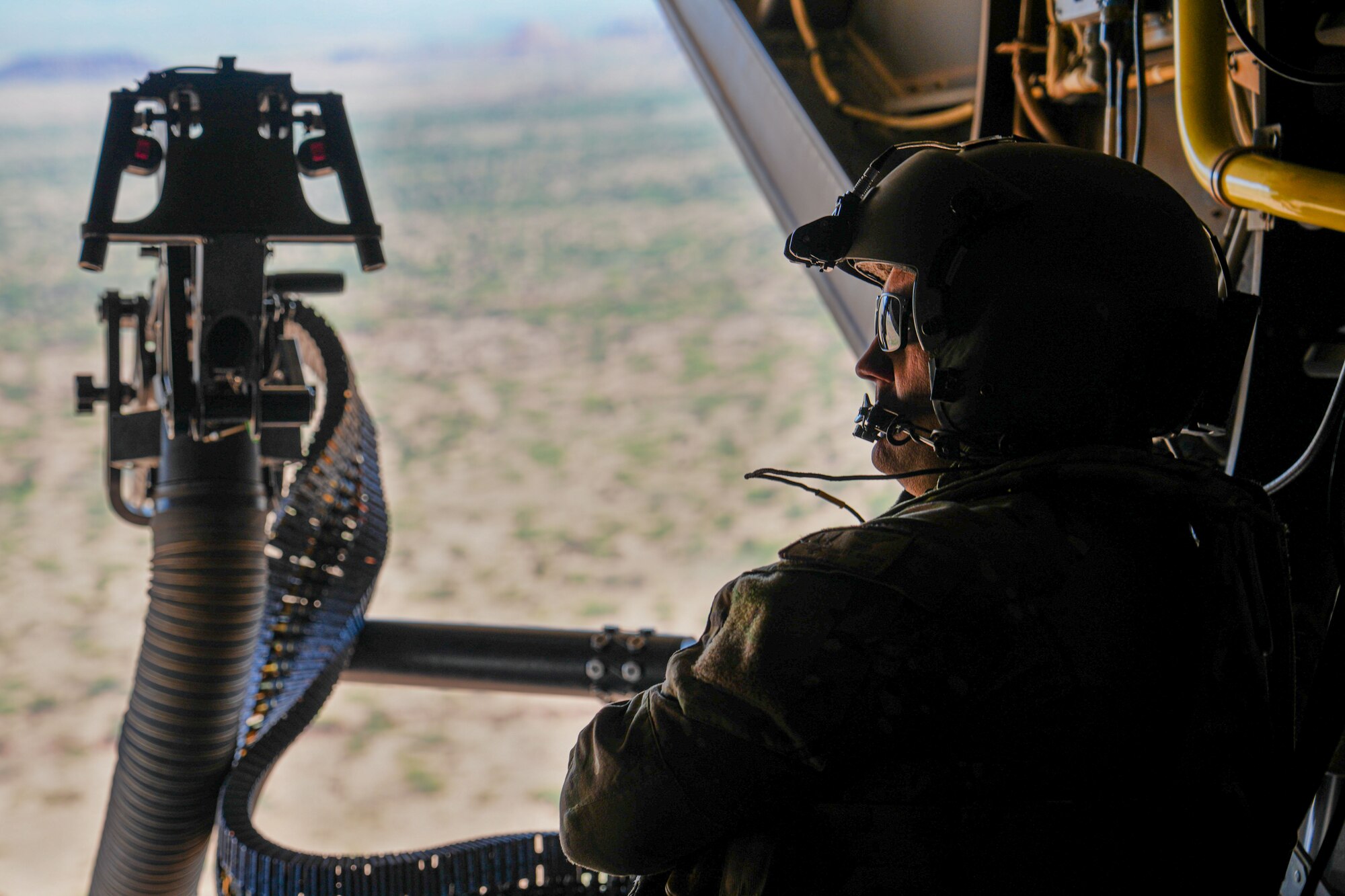 U.S. Air Force Tech. Sgt. Brett McGee, special missions aviator assigned to the 20th Special Operations Squadron, sits in the back of a CV-22 Osprey as it flies during a training exercise over the plains of New Mexico, Oct. 9, 2024. The CV-22's unique capabilities provide Special Operations Forces Mobility for joint, allied and combined forces, solving challenges found in contested and denied environments. (U.S. Air Force photo by Airman 1st Class Gracelyn Hess)