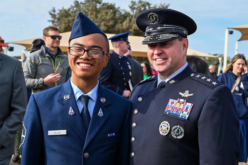 Two service members smile while posing for a picture.