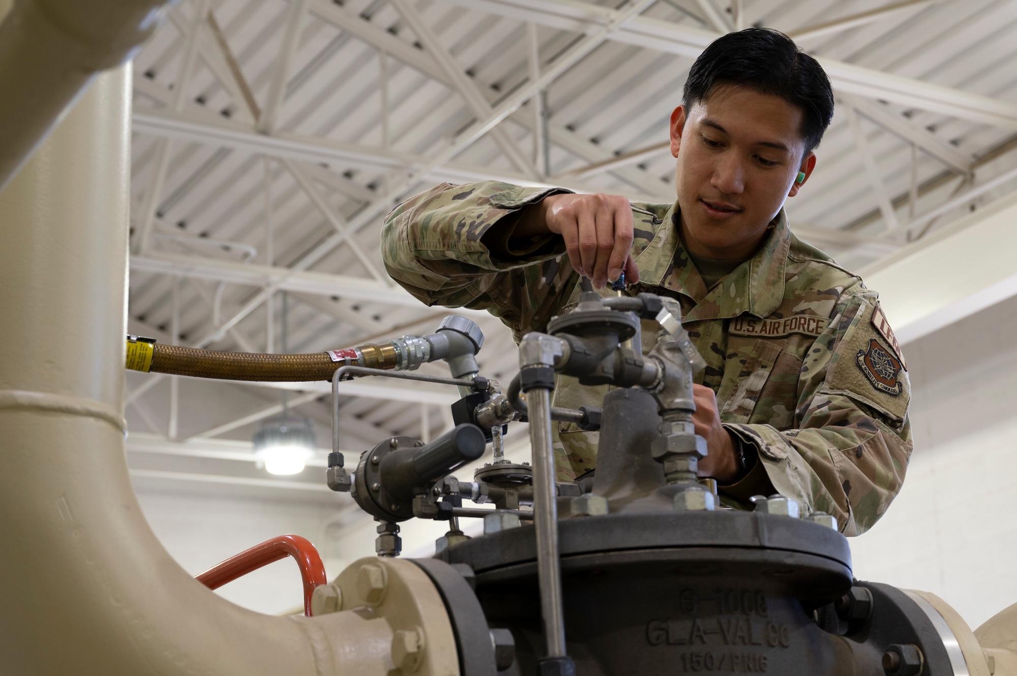 U.S. Air Force Senior Airman Aaron Vincent Gumafelix, a fuels systems maintenance specialist assigned to the 92nd Civil Engineering Squadron, adjusts the rate of flow valve at Fairchild Air Force Base, Washington, Oct. 1, 2024. These weekly adjustments ensured that the machinery was in proper working condition to provide fuel to the flightline. (U.S. Air Force photo by Airman 1st Class Samantha Thorn)