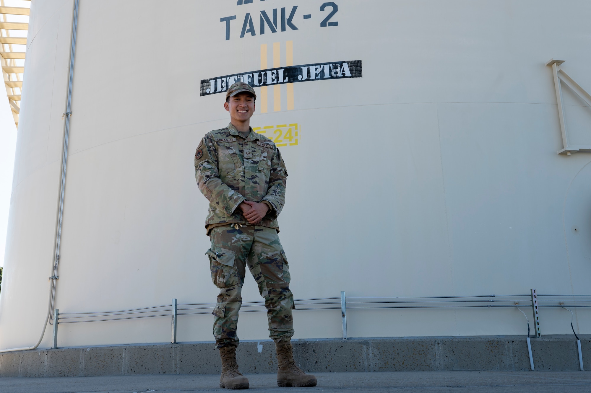 U.S. Air Force Senior Airman Aaron Vincent Gumafelix, a fuels systems maintenance specialist assigned to the 92nd Civil Engineer Squadron, poses for a photo outside of a fuel tank at Fairchild Air Force Base, Washington, Oct. 1, 2024. Gumafelix played a crucial role in ensuring the efficiency of the fueling systems by maintaining and optimizing fuel transportations. (U.S. Air Force photo by Airman 1st Class Samantha Thorn)