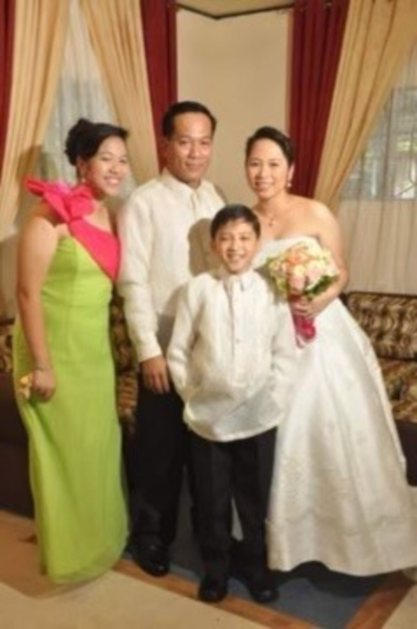 A man poses with his family for a photo during a wedding celebration