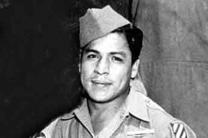 A man in cap and uniform smiles for a photo.